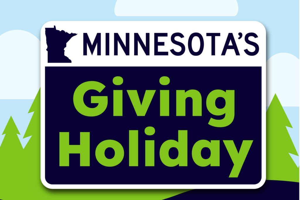 Road sign reading 'Minnesotas Giving Holiday' over illustrated landscape of evergreen trees and clouds and word mark for Give to the Max, Nov. 18, 2021