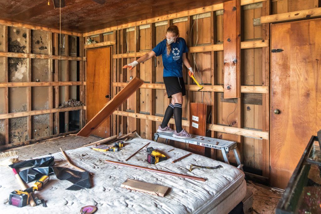 Photo: A NECHAMA volunteer removes wood from walls in a home damaged by Hurricane Ida in Louisiana