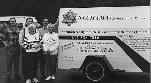 NECHAMA IS BORN! The first group of volunteers with NECHAMA stand next to the first trailer purchased.