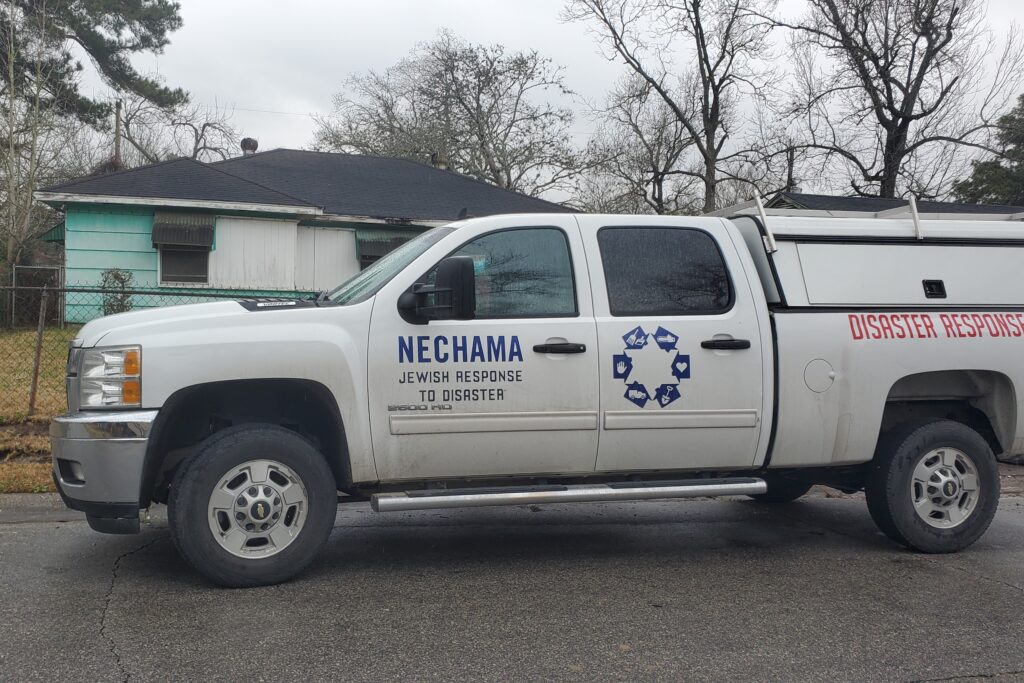 White pick up truck with Nechama logo